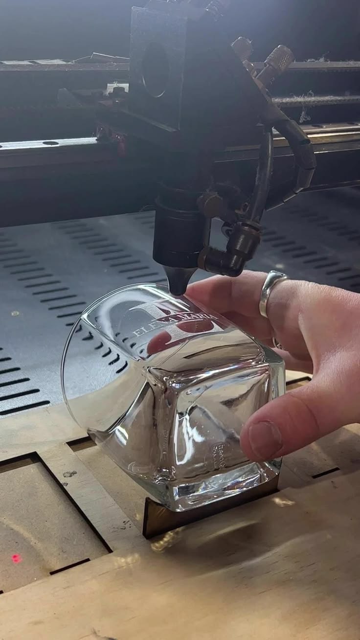 Laser engraving a glass tumbler held in the machine bed